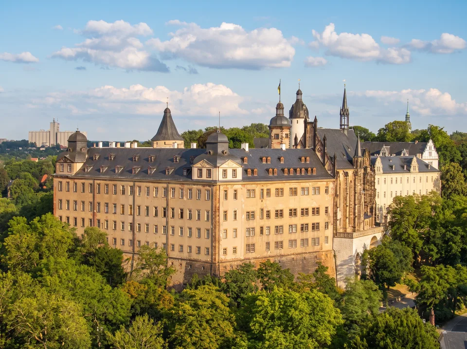 Das Residenzschloss Altenburg mit langem barocken Hauptflügel, Schlosskirche und Türmen über grünen Bäumen