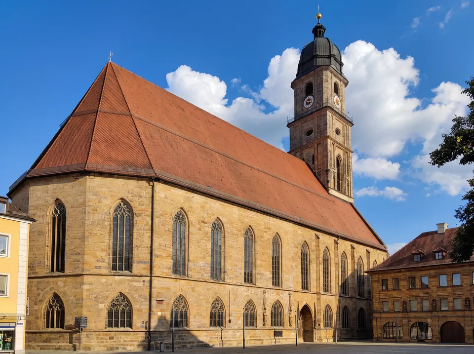 Die gotische Basilika St. Martin in Amberg mit rotem Steildach und hohem Turm am Marktplatz