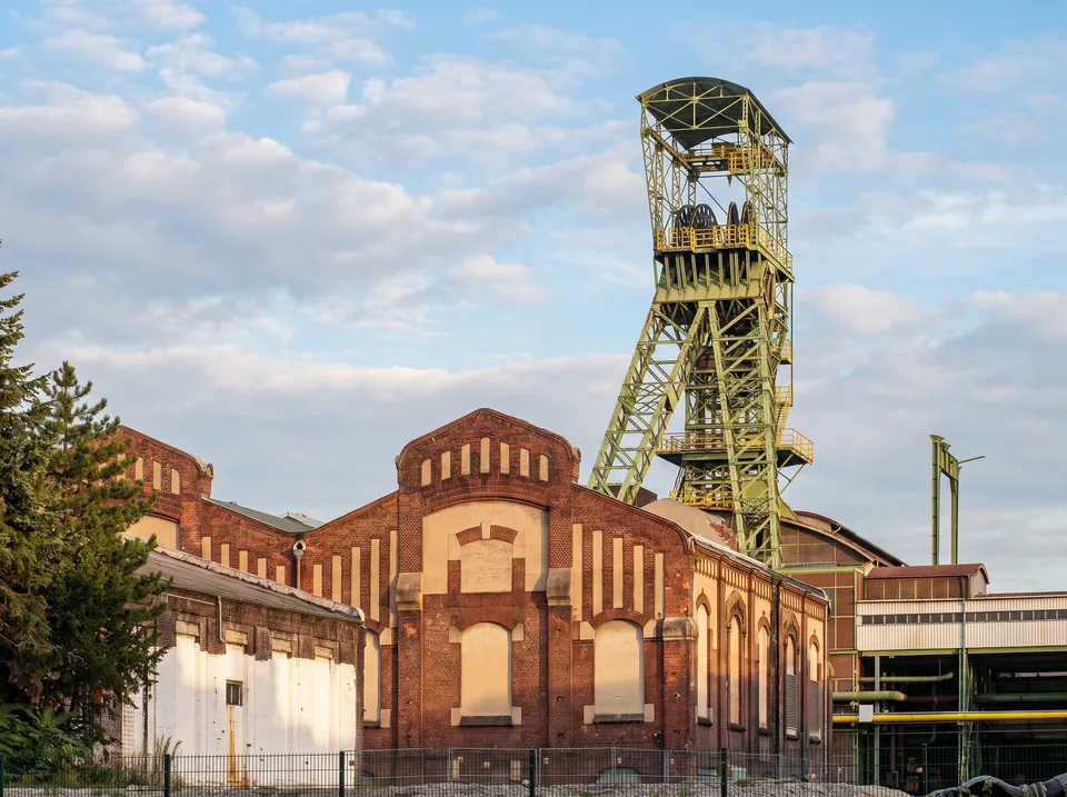 Das grüne Fördergerüst über Schacht 1 der ehemaligen Zeche Lohberg hinter roten Backsteinhallen
