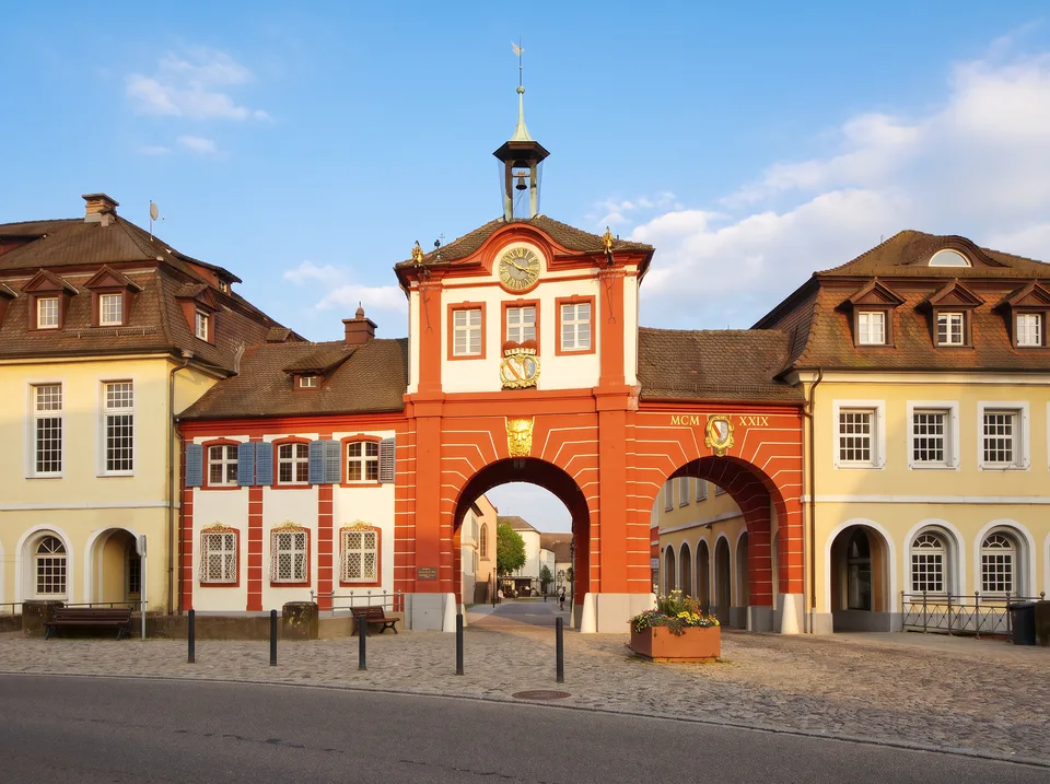 Das rot-weiße Stadttor von Emmendingen mit Uhrengiebel, Dachreiter und Torbögen zwischen hellen Altstadthäusern