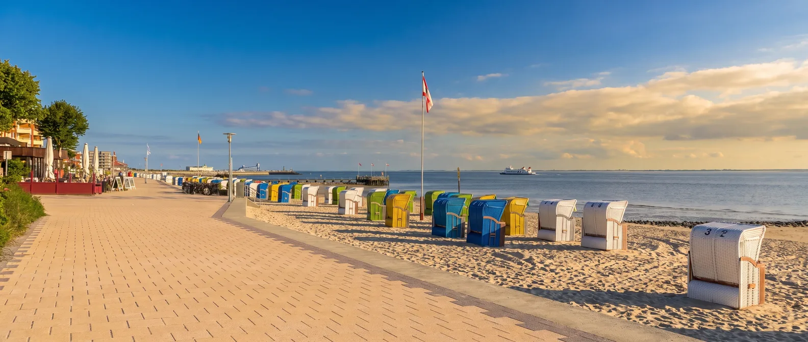 Strandpromenade Sandwall in Wyk auf Föhr mit bunten Strandkörben am Sandstrand und Blick aufs Wattenmeer im Abendlicht