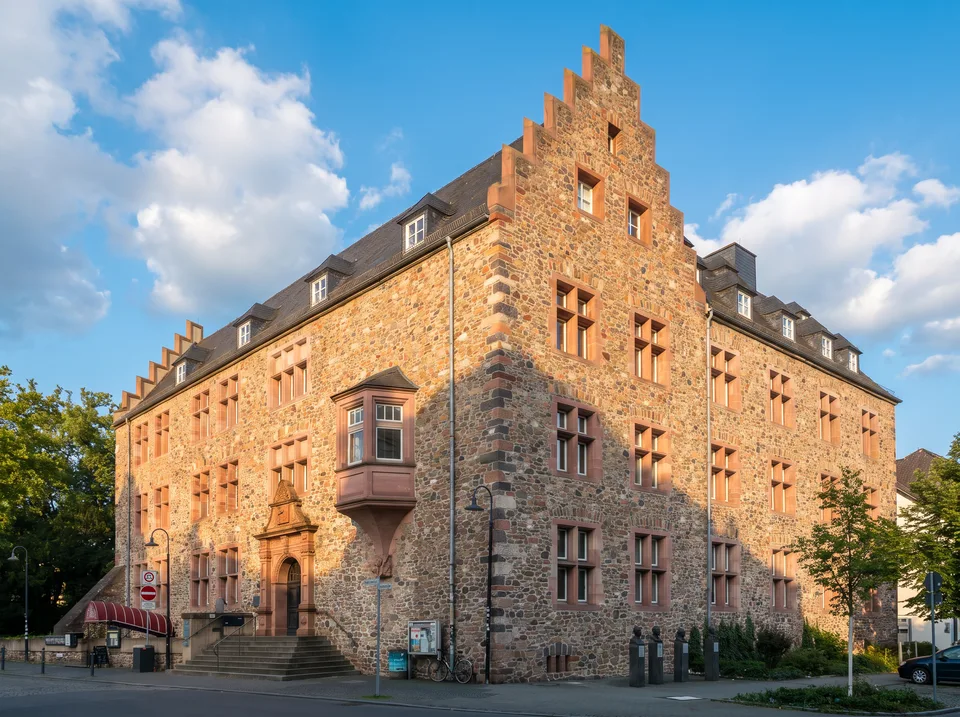 Altes Schloss in Gießen mit Bruchsteinfassade, Stufengiebel und Erker in der Nachmittagssonne