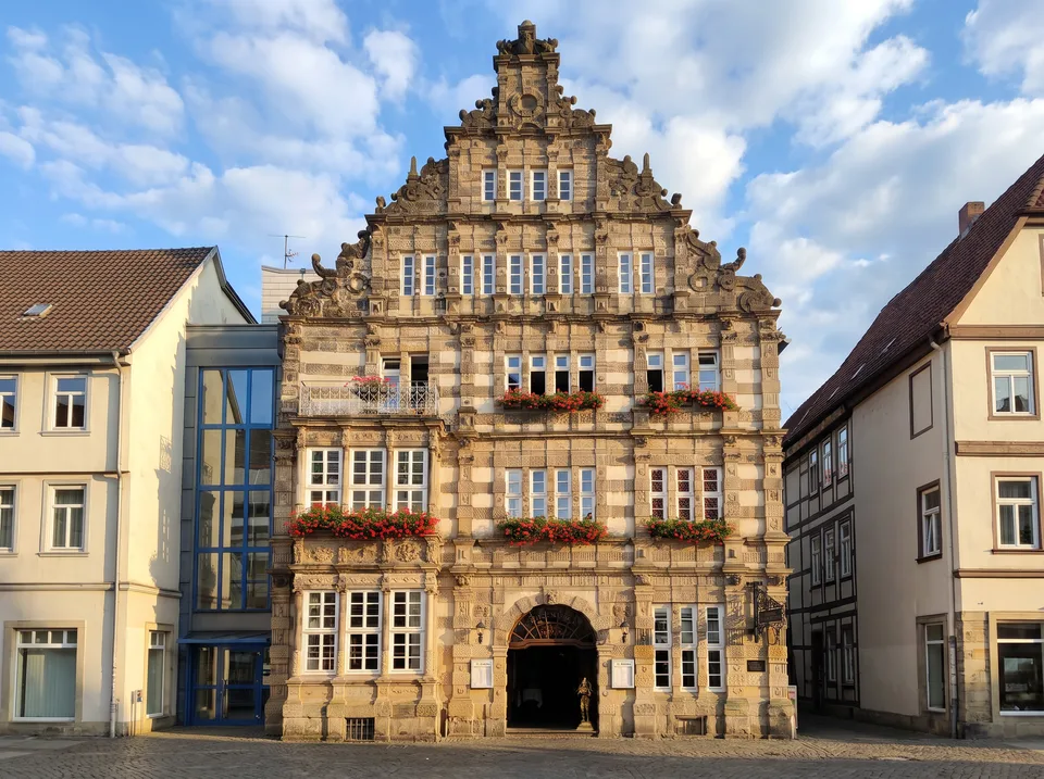 Das Rattenfängerhaus in Hameln mit reich verzierter Sandsteinfassade der Weserrenaissance, hohem Ziergiebel und roten Blumenkästen