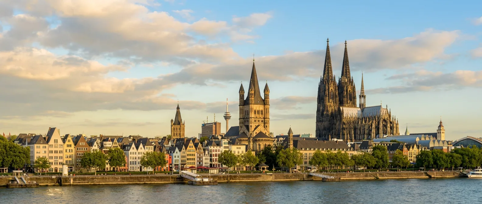 Kölner Rheinufer mit bunten Altstadthäusern, Groß St. Martin und dem Kölner Dom im goldenen Abendlicht