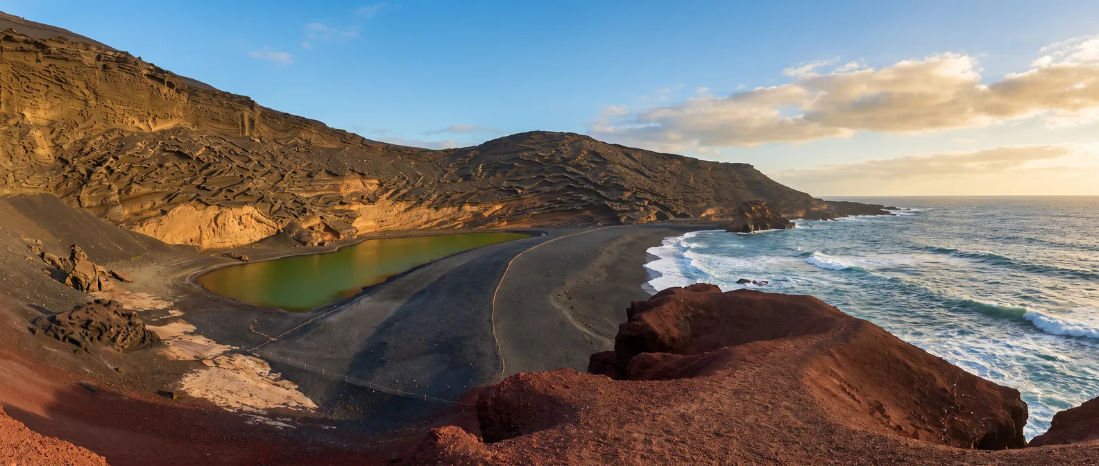 Halb im Meer versunkener Vulkankrater von El Golfo mit der grünen Lagune Charco de los Clicos, schwarzem Lavastrand und roten Lavafelsen