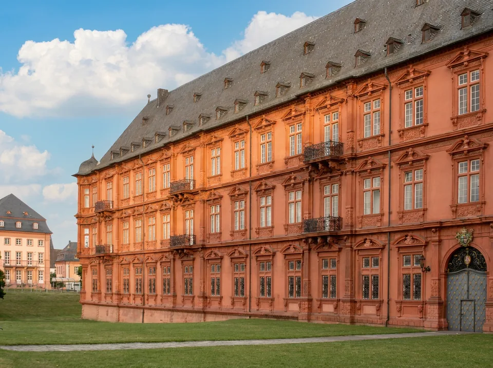 Die reich verzierte rote Sandsteinfassade des Kurfürstlichen Schlosses in Mainz mit Schieferdach und Dachgauben