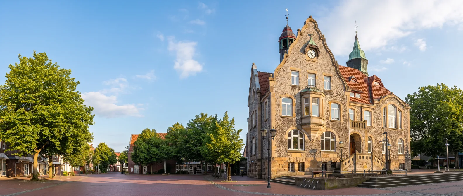 Das Rathaus von Melle aus Bruchstein mit geschwungenem Giebel, Uhr und grünem Kupferturm am Marktplatz
