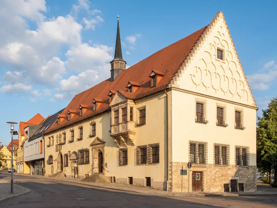 Das Alte Rathaus in Merseburg mit hohem Ziergiebel, rotem Dach, Dachreiter und Renaissance-Erker
