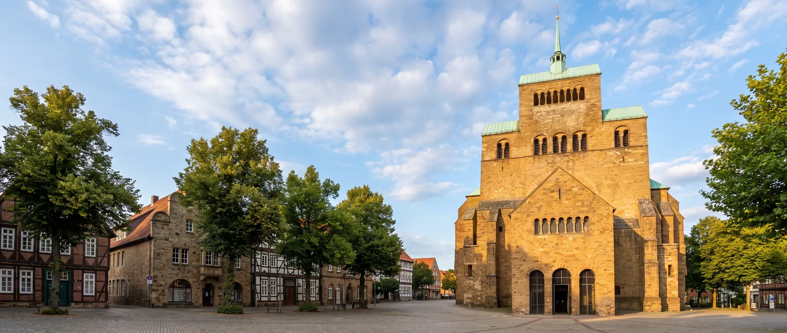 Das romanische Westwerk des Mindener Doms mit grünen Kupferdächern und schlanker Turmspitze im Abendlicht