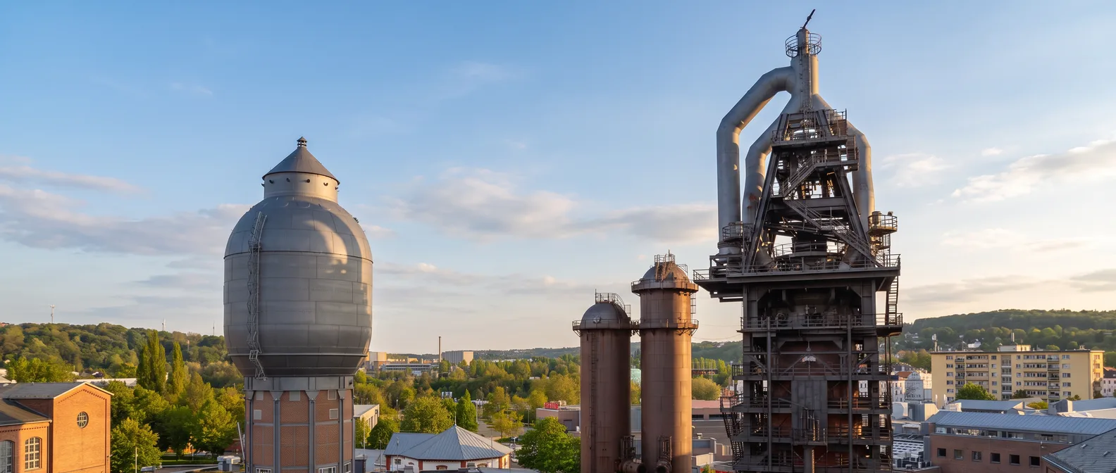 Das Alte Hüttenareal in Neunkirchen mit dem Hochofen, zwei rostbraunen Winderhitzern und dem Wasserturm im Abendlicht