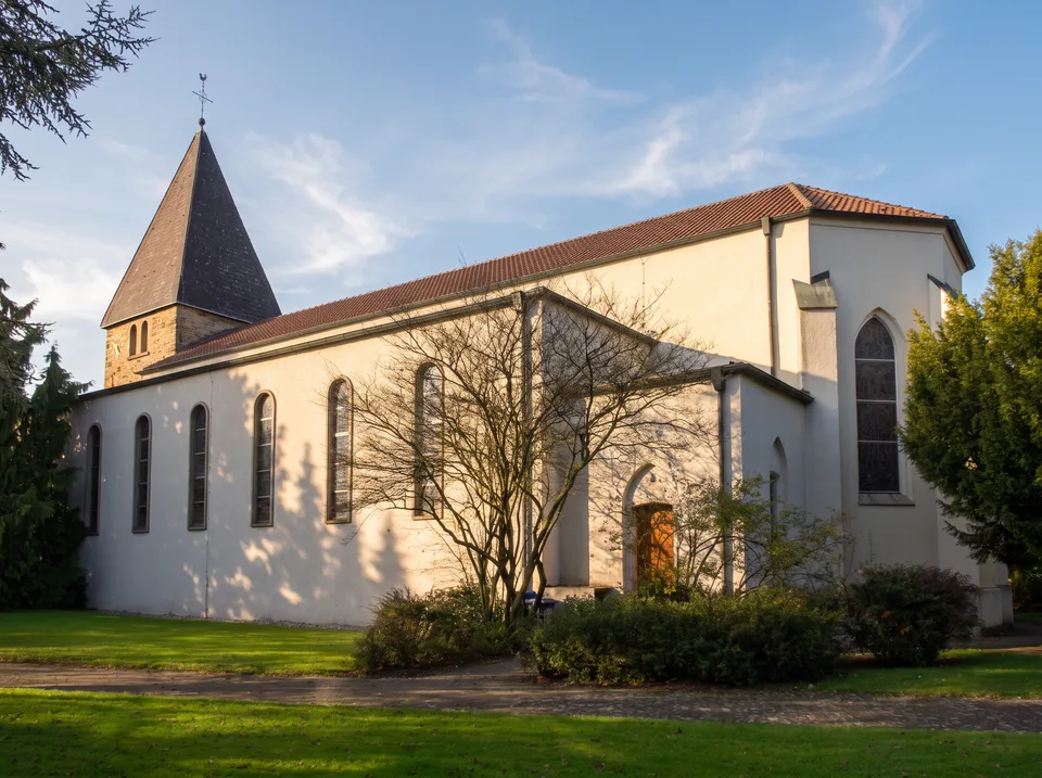 Die weiße Kirche St. Peter und Paul in Oer mit rotem Ziegeldach und altem Bruchsteinturm mit Pyramidendach