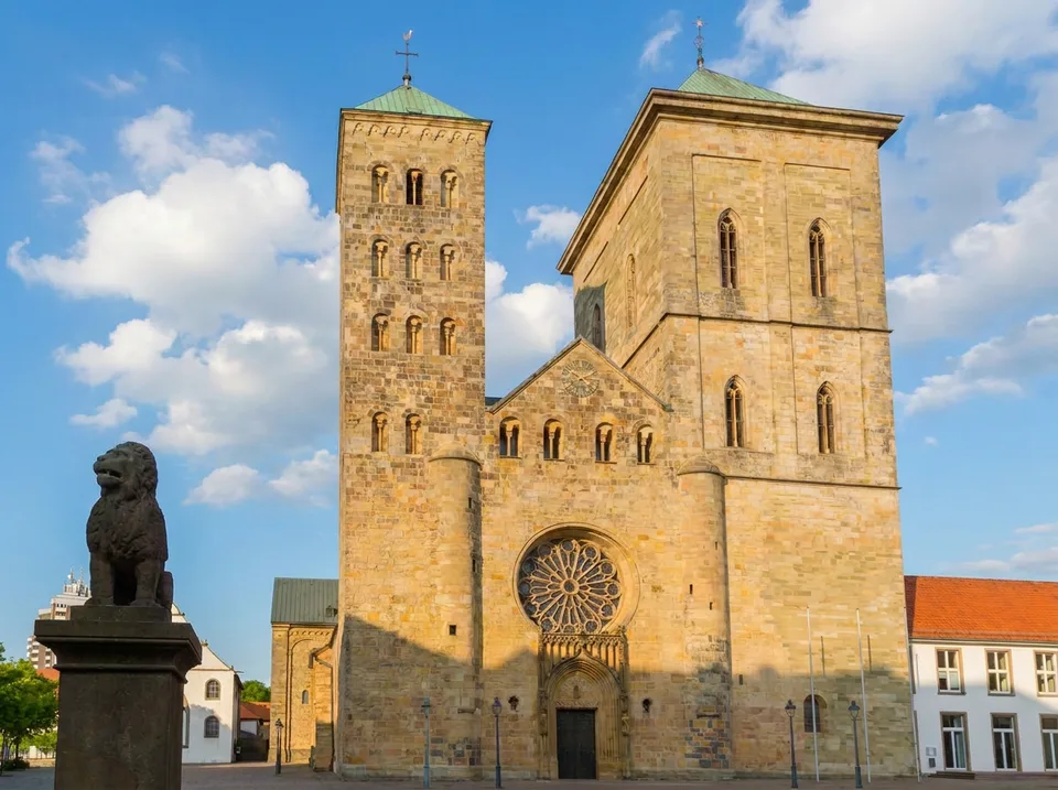 Dom St. Peter in Osnabrück mit seinen zwei unterschiedlichen Westtürmen und dem Löwenpudel-Standbild