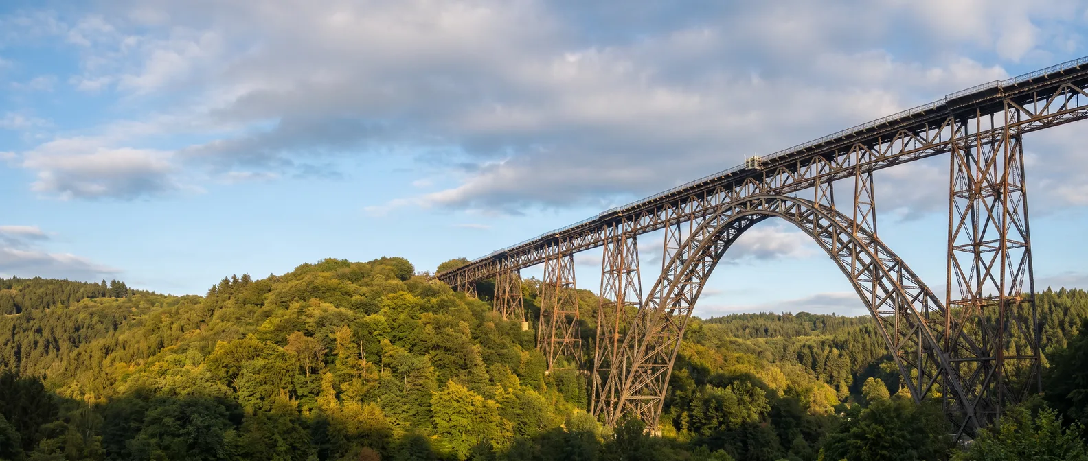 Die stählerne Müngstener Brücke mit ihrem großen Bogen über dem bewaldeten Tal der Wupper bei Remscheid