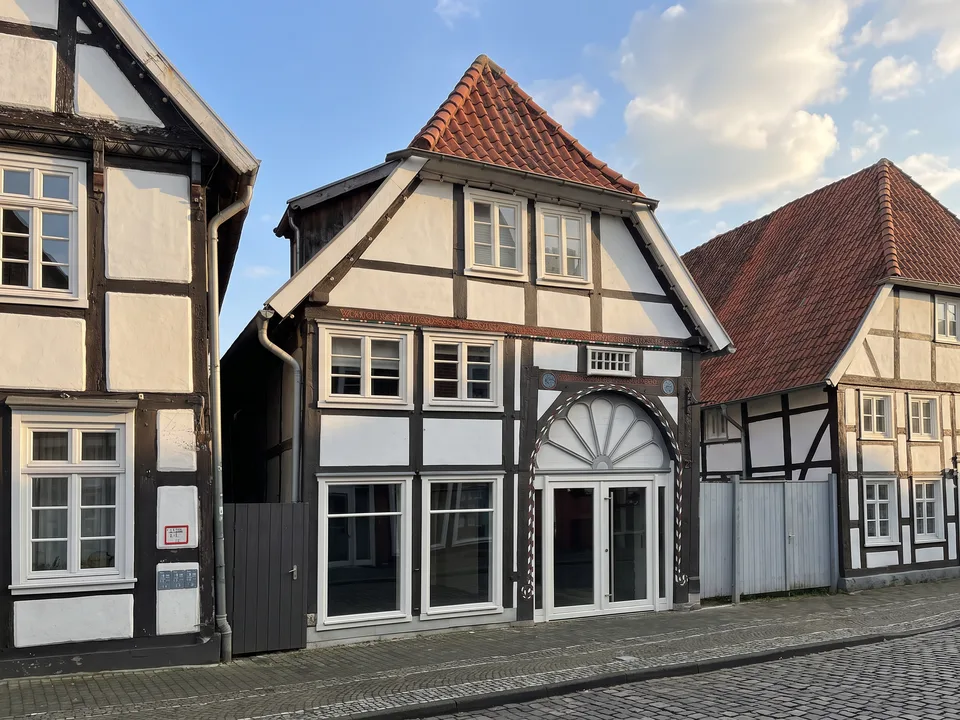Das schmale Fachwerkhaus Lange Straße 27 in Wiedenbrück mit Krüppelwalmdach und verziertem Dielentor