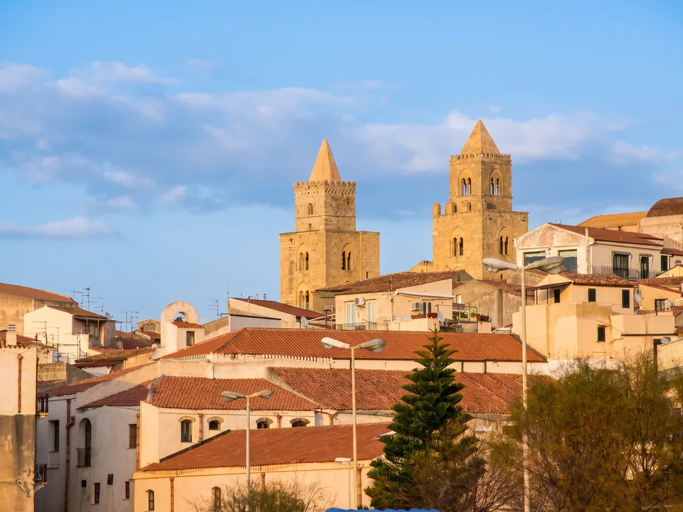 Die beiden normannischen Türme der Kathedrale von Cefalù über den roten Ziegeldächern der Altstadt