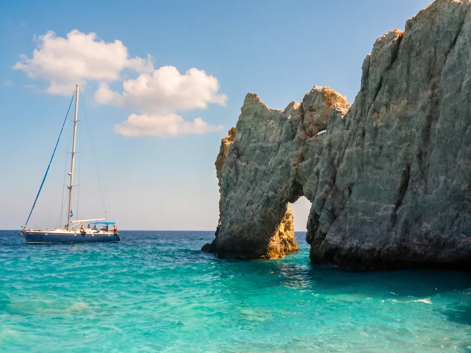 Felsenbogen Trypia Petra am Strand Lalaria auf Skiathos mit türkisfarbenem Wasser und Segelboot