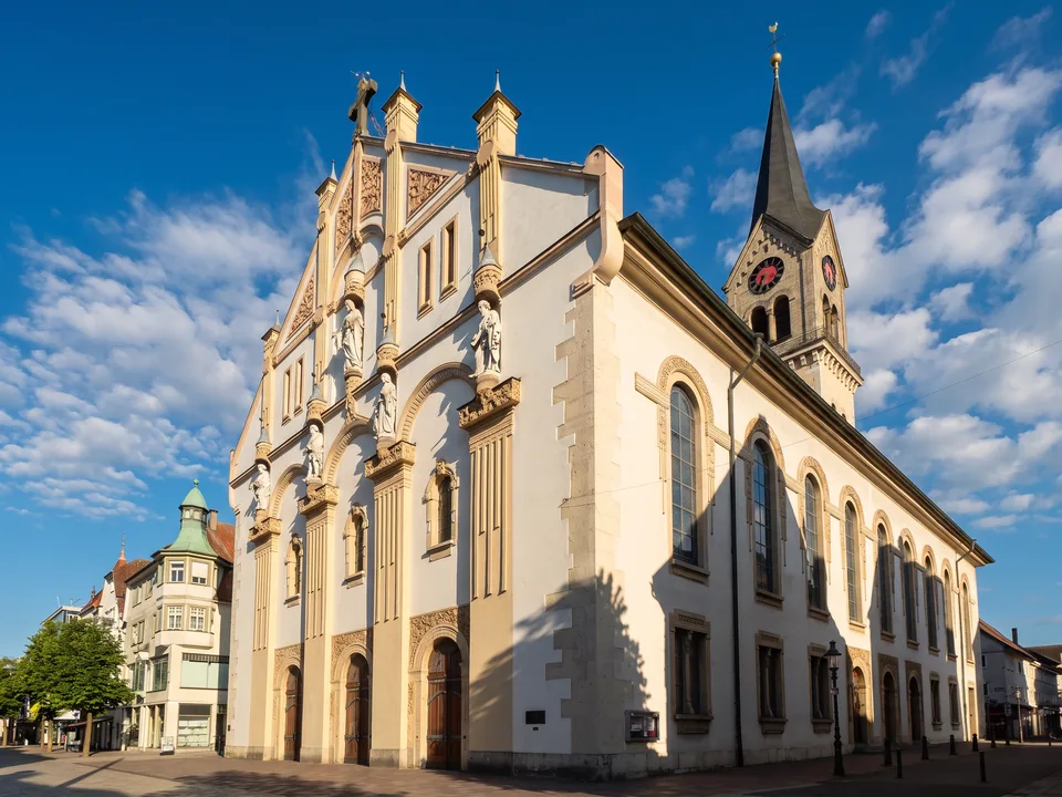 Die evangelische Stadtkirche Tuttlingen mit reich gegliederter heller Fassade, Figuren und spitzem Glockenturm