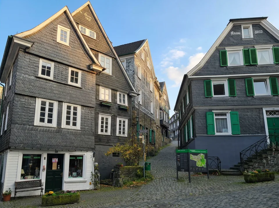 Verschieferte Fachwerkhäuser mit grünen Fensterläden an einer Kopfsteinpflaster-Gasse in der Altstadt von Velbert-Langenberg