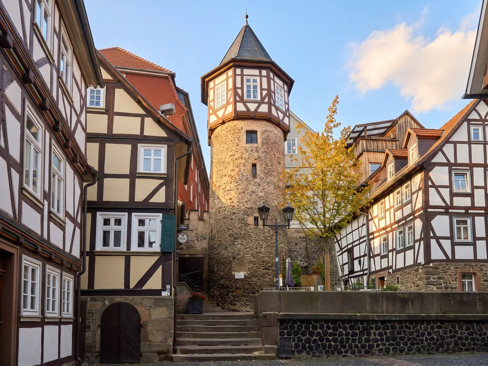 Runder Ankerturm aus Bruchstein mit Fachwerkaufsatz und spitzem Schieferdach zwischen Fachwerkhäusern in Lauterbach