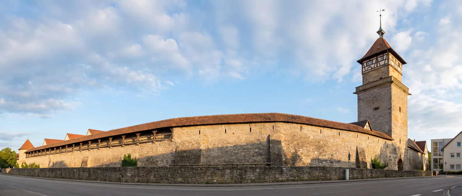 Hochwachtturm in Waiblingen mit Fachwerkgeschoss und rotem Ziegeldach an der langen mittelalterlichen Stadtmauer unter blauem Himmel