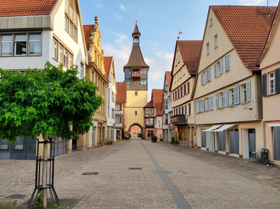 Blick durch die Marktstraße in Winnenden auf den Schwaikheimer Torturm mit Torbogen, Uhr und spitzem Turmhelm